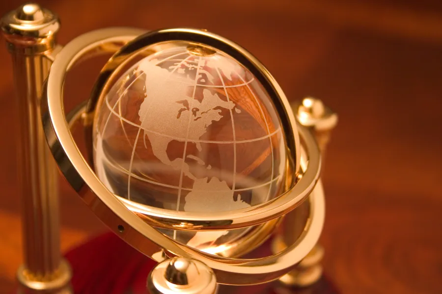 Globe en cristal doré sur socle, symbolisant l’accompagnement énergétique à distance dans le monde francophone