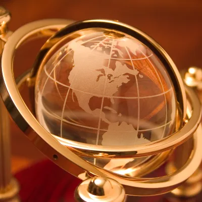 Globe en cristal doré sur socle, symbolisant l’accompagnement énergétique à distance dans le monde francophone