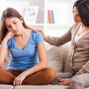 Adolescente en détresse émotionnelle réconfortée par sa mère, symbole du soutien aux jeunes dyslexiques, hypersensibles ou TDAH