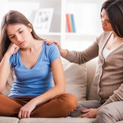 Adolescente en détresse émotionnelle réconfortée par sa mère, symbole du soutien aux jeunes dyslexiques, hypersensibles ou TDAH