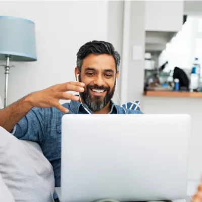 Homme d’affaires souriant en séance de coaching en ligne, accompagnement neuroénergétique pour cadres et dirigeants