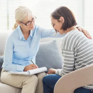 Coach bienveillante qui accompagne une maman en détresse face aux difficultés de son enfant neuroatypique