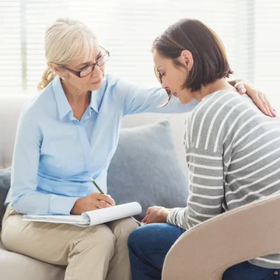 Coach bienveillante qui accompagne une maman en détresse face aux difficultés de son enfant neuroatypique
