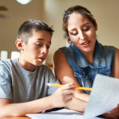 Adolescent dyslexique faisant ses devoir avec sa maman. Et reprenant confiance en lui.