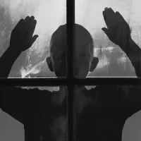 Silhouette derrière une vitre, illustrant les blessures émotionnelles d’enfance ou relationnelles