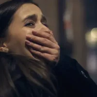 Femme cachant son visage dans l’ombre, évoquant un choc émotionnel ou un traumatisme non résolu